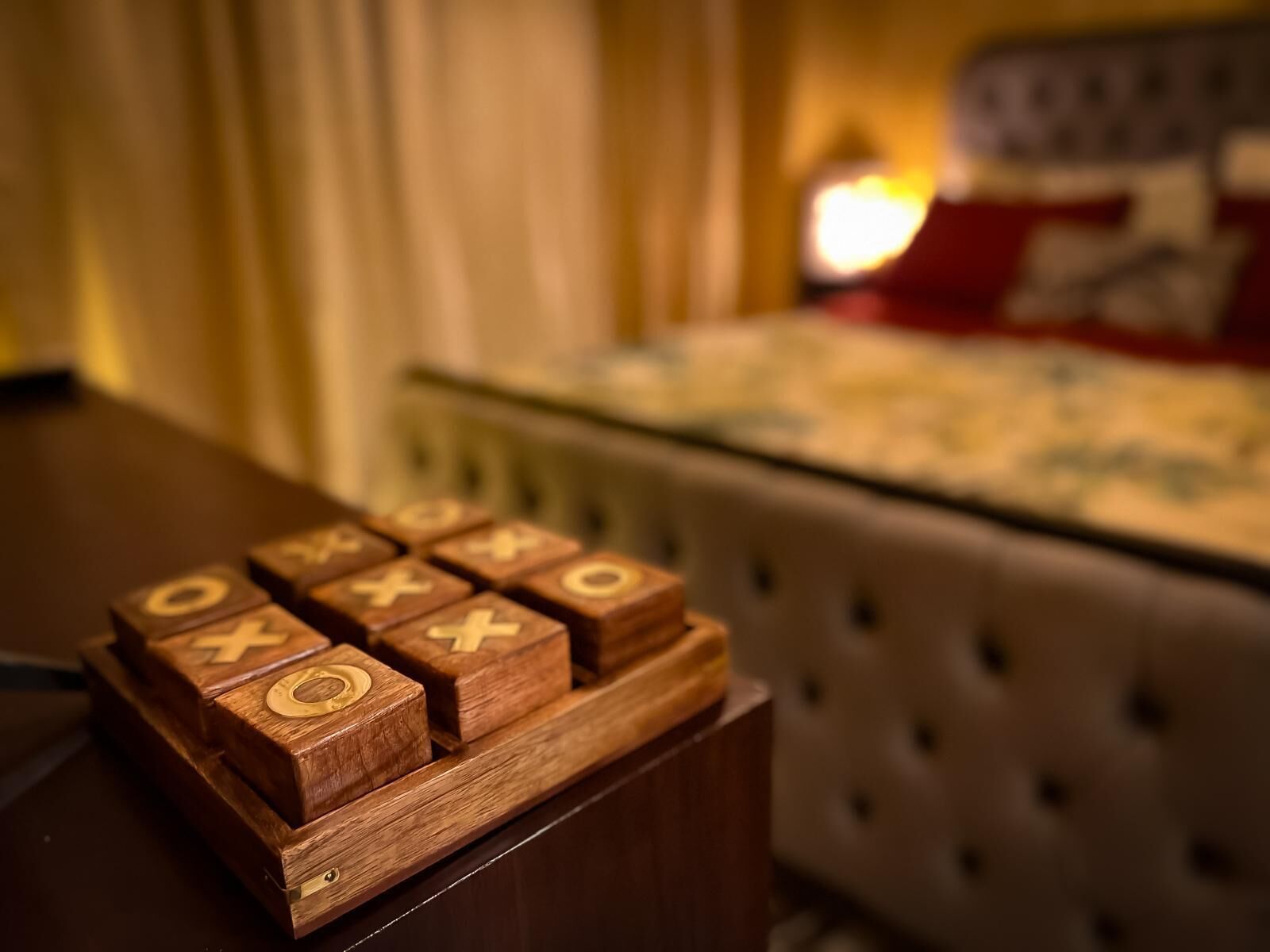 Un jeu de construction en bois avec des lettres, posé sur une table dans une chambre d’hôtel.