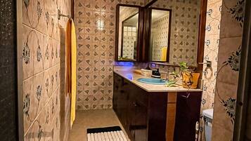 Ein Badezimmer mit Wandmustern, einem Spiegel, einem Waschbecken und einer Toilette.