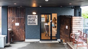 A hotel entrance with a sign reading "HOTEL BASE NARA," wooden doors, and a seating area outside. - Hotel Base Nara (Nara)