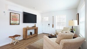 A living room with a fireplace, a television mounted on the wall, and a comfortable seating area with a sofa and armchairs. - Morgan's at the Little Red - Double Queen Cabin 5 (Heber Springs, AR)