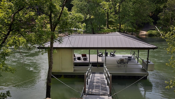 Ein schwimmendes Haus mit Anlegesteg, Außenbereich und Blick auf das Wasser.