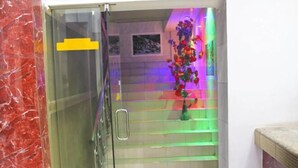 Puerta de cristal que da a una escalera con iluminación colorida.