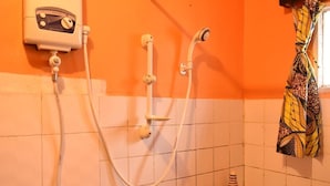 A bathroom with a shower, a handheld showerhead, and a wall-mounted control panel. - Room in B&B - Amahoro Guest House - Double Room With Private Shower Room (Muhoza)