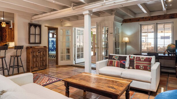 Un vaste espace de vie agrémenté d’un canapé blanc, d’une table basse en bois et d’un tapis à motifs.