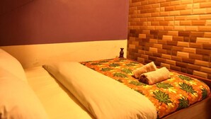 Een hotelkamer met een bed, een houten hoofdbord en een muur met een bakstenen patroon.