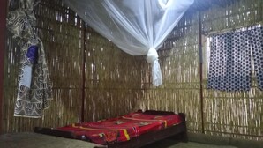 Une chambre avec un lit, une moustiquaire et un rideau à motifs.