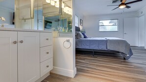 A bedroom with a bed, a ceiling fan, and a window.