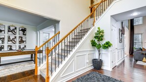 A staircase with white railings and wooden handrails, leading to an upper floor. - Modern Stone Mountain Home w/ Spacious Deck, Grill (Stone Mountain)