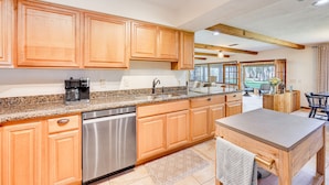 A modern kitchen with wooden cabinets, stainless steel appliances, and a granite countertop. - Unique Melrose Home w/ Private Dock & Lake Access! (Melrose)
