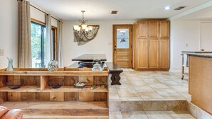 A wooden bench with a vase and a bowl, a chandelier, a wooden door, and a tiled floor. - Unique Melrose Home w/ Private Dock & Lake Access! (Melrose)