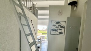 A staircase leading to a second floor with a view of an outdoor patio area. - Appartement Front de Mer, Pleine Vue Mer, 5 Per, Wifi, Piscine, Animaux Acceptés (Agde)