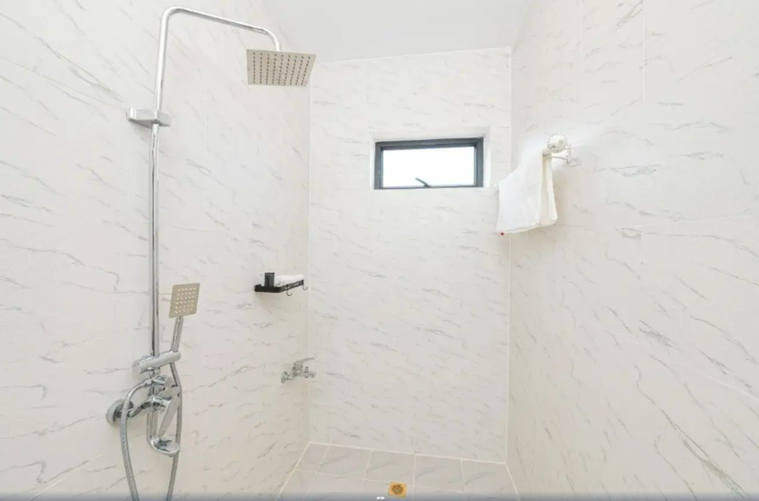 A shower with a handheld showerhead, a wall-mounted rain showerhead, and a handheld faucet.