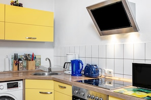 A kitchen with a built-in oven, a coffee maker, and a kettle on the counter. - Apartment 'Thüringer Wald' with Wi-Fi (Ilmenau)