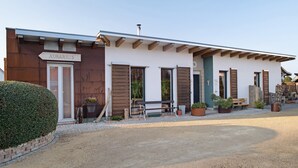 Un bâtiment sur lequel on peut lire l’inscription « AURARIUS », un banc en bois et des plantes en pot.