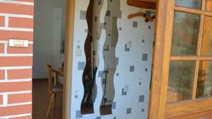 A doorway with a unique wavy design, a wooden door with glass panels, and a herringbone-patterned floor.
