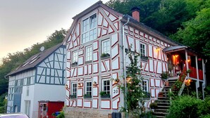 Um edifício tradicional em enxaimel com fachada vermelha e branca, com o número '20' visível, e uma escadaria que leva à entrada.