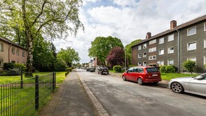 Eine Wohnstraße mit Häusern, Bürgersteig und parkenden Autos.