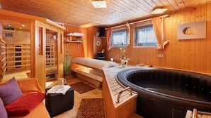 Arredamento in legno con sauna, vasca da bagno e divano.