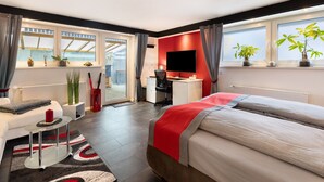 Una camera d'hotel moderna con un letto, una scrivania e ampie finestre.
