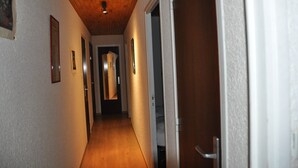A narrow hallway with wooden ceiling and white walls, leading to a door at the end. - Apt 4/6 ppl with balcony, near the ski station (Les Deux Alpes)