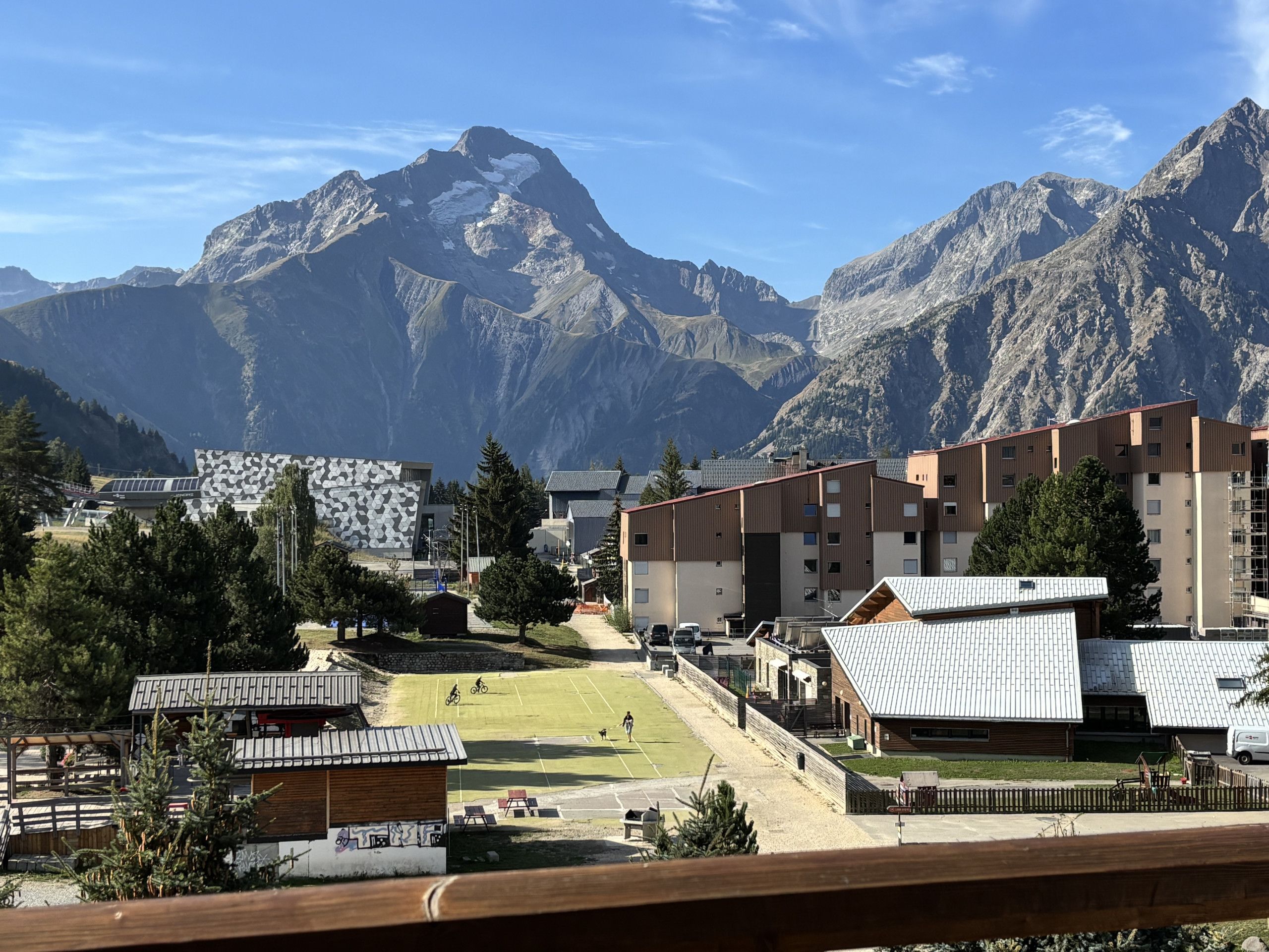 Landskab med bjerge, moderne bygninger, en sportsplads og en skilift.