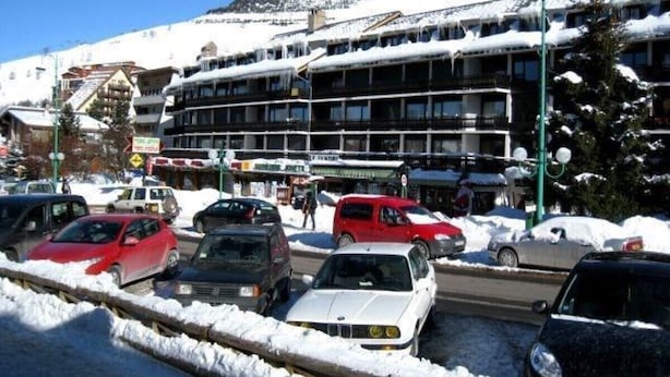 A hotel with multiple floors and a snow-covered mountain in the background.