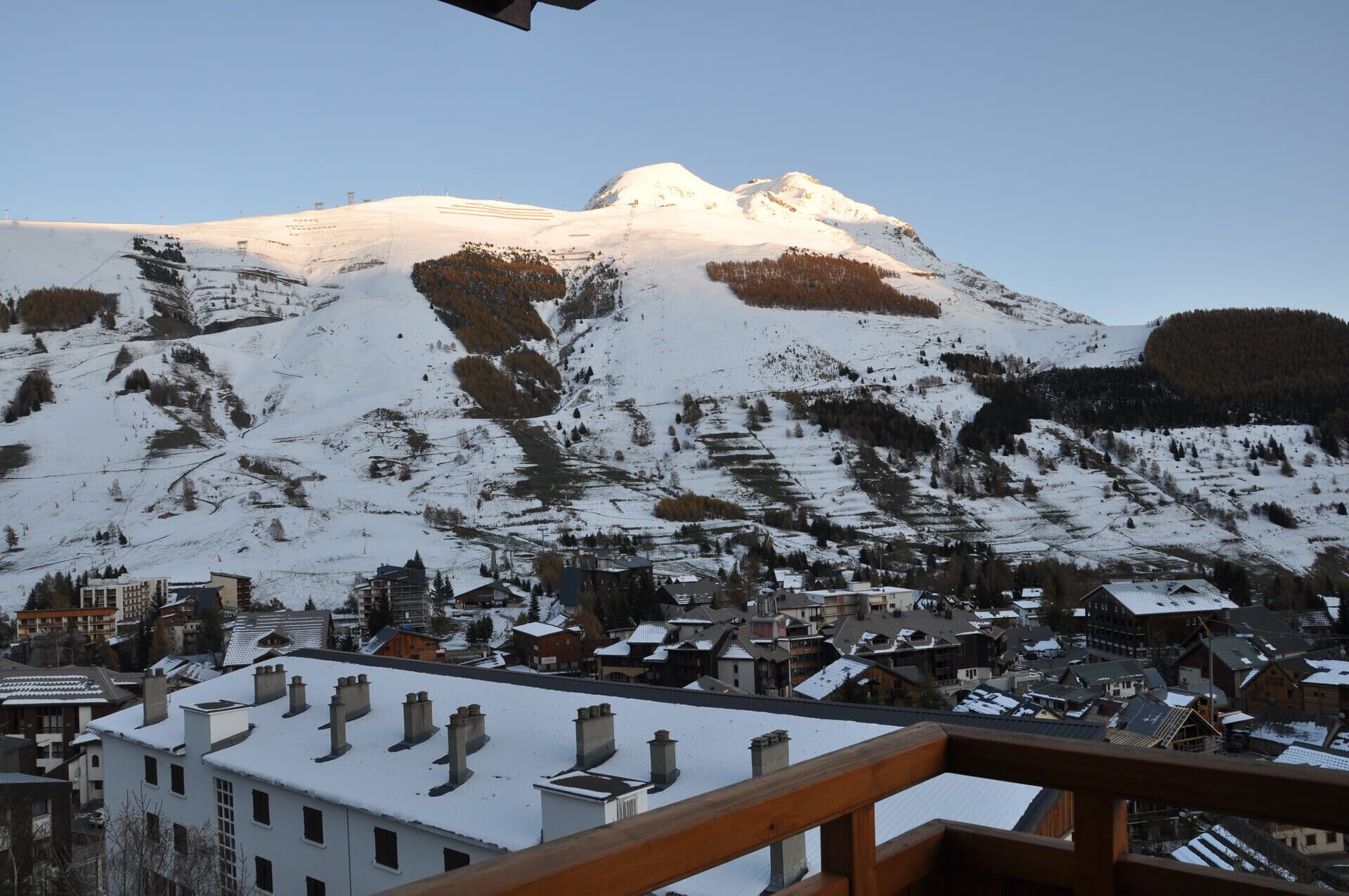 A snow-covered mountain with a town at its base.