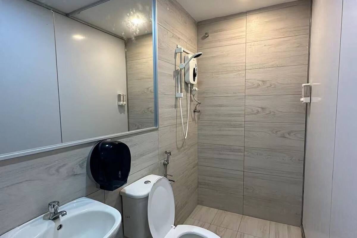 A modern bathroom with a sink, toilet, and shower.