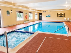 An indoor swimming pool with a hot tub, tiled walls, and a lifebuoy. - Sweetwater Lodge (Rock Springs)