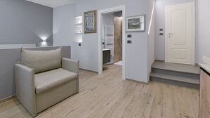 A modern interior with a sofa, a hallway leading to a bathroom, and a staircase. - SarMay DeLuxe Apartment ( 2monolocale connected) (bologna)