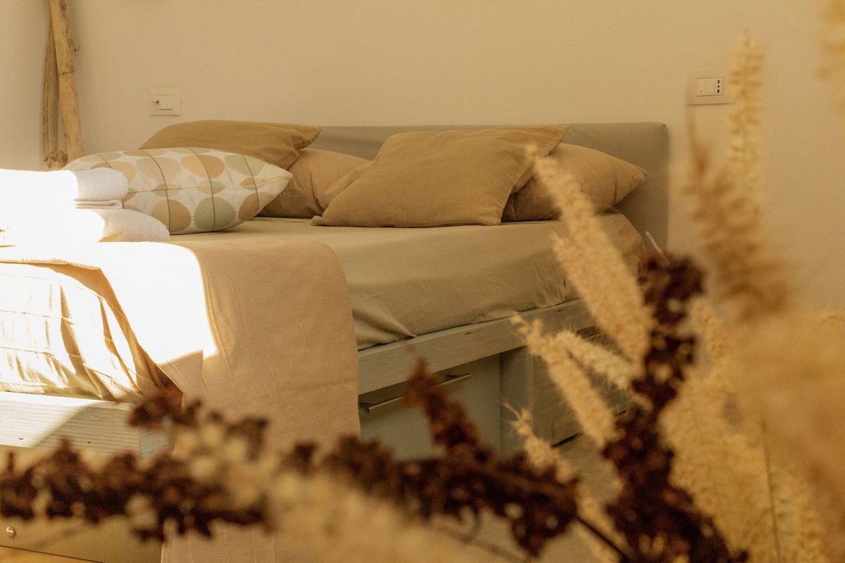 Une chambre à coucher avec un lit, des oreillers et une table de chevet.