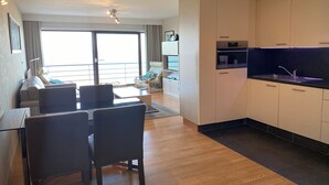 A modern apartment with a dining area, kitchen, and a balcony with a view. - Apartment in Nieuwpoort near Sandy Beaches (Nieuwpoort)