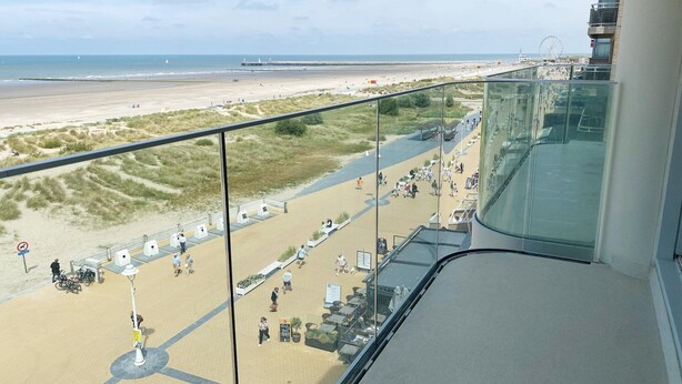 Un balcon donnant sur la plage, avec vue sur la plage, une grande roue et une jetée au loin.