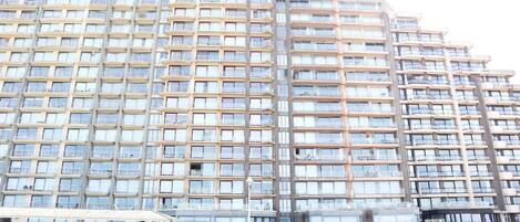 A multi-story hotel with a uniform facade, large windows, and balconies.