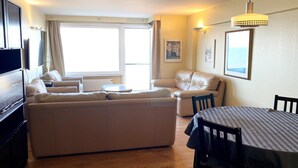 Una sala de estar moderna con un sofá, una mesa de comedor y un televisor.