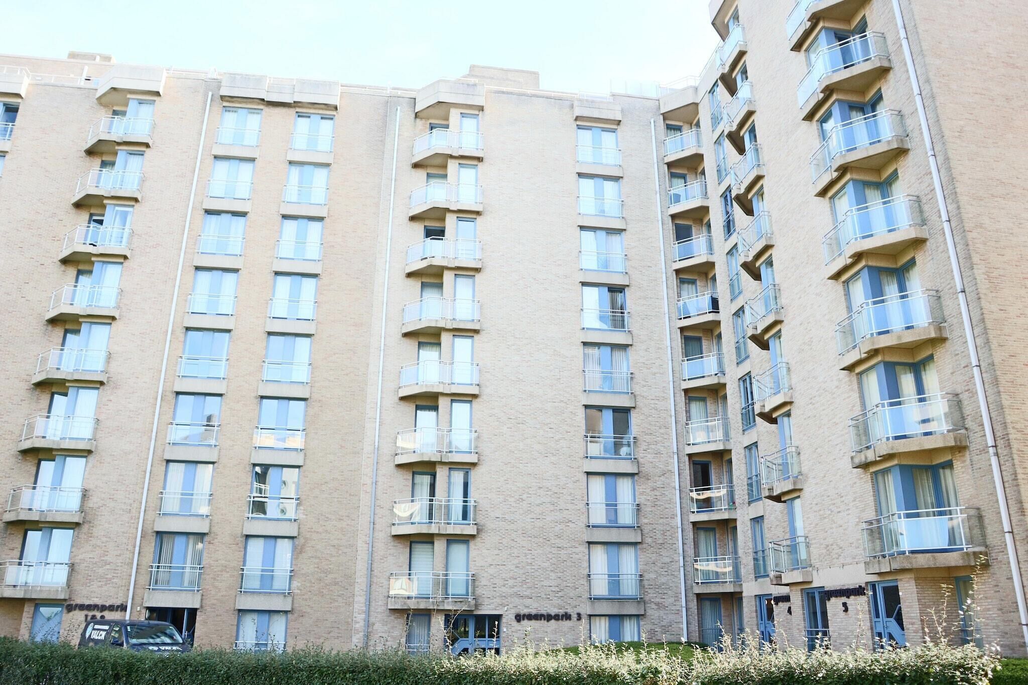 Un immeuble résidentiel à plusieurs étages, doté de balcons, d’une entrée bien visible et d’une enseigne indiquant « greenpark 3 ».