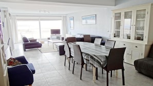 Un vaste espace de vie comprenant une table à manger, des chaises, des canapés et un meuble.