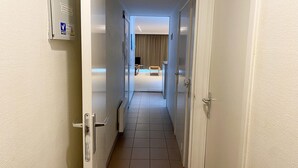 Un pasillo de hotel que da a una habitación con cama y ventana.