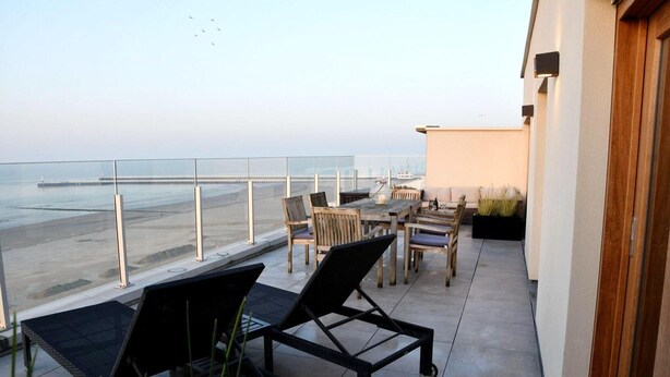 A balcony with a view of the sea, furnished with chairs and a table. - Attic Apartment in Nieuwpoort by the Beach (Nieuwpoort)