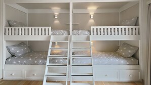 A bunk bed with a ladder, two pillows, and a star-patterned bedspread. - Apartment Nieuwpoort near Beach and Marina (Nieuwpoort)