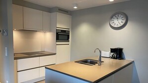 A modern kitchen with a built-in oven, a sink, and a coffee maker. - Apartment in Nieuwpoort near the Beach (Nieuwpoort)