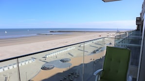 A balcony with a view of a beach, a pier, and a distant tower. - Apartment in Nieuwpoort by the North Sea (Nieuwpoort)