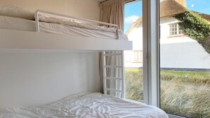 A bunk bed room with a window view of a house and grass. - Apartment in Nieuwpoort by Beach (Koksijde)