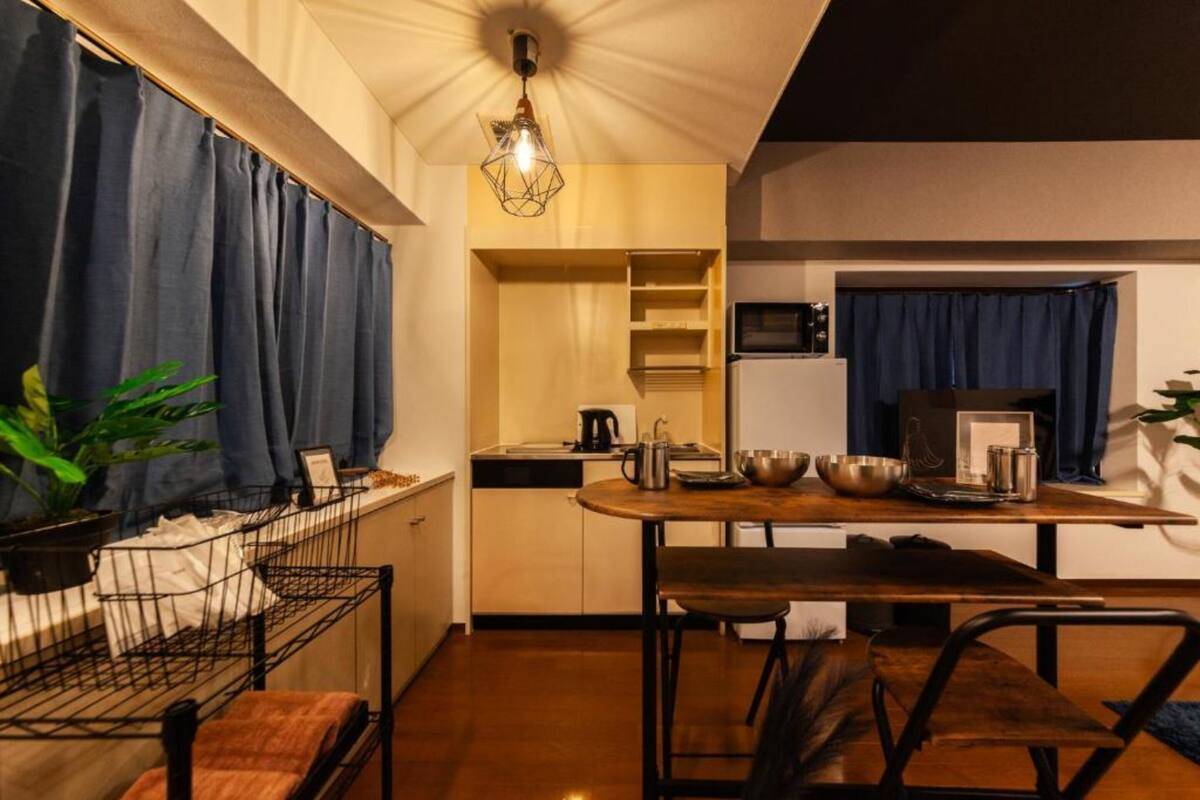 A compact kitchen with a dining area, featuring a built-in microwave, a kettle, and a coffee maker.