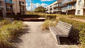 Un camino que lleva a un banco en una zona residencial con edificios de apartamentos modernos.