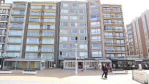 A multi-story residential building with balconies, a covered entrance, and a cafe named "PRINCIPAL" on the ground floor. - Apartment in Nieuwpoort by Sandy Beaches (Nieuwpoort)