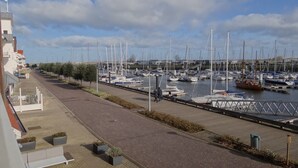 A marina with boats docked along a paved walkway.
