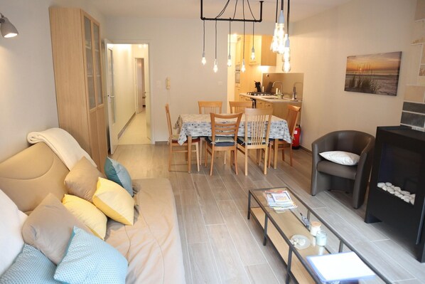 Un salon comprenant un canapé, une table à manger, des chaises et une cheminée.