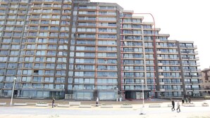 Een meerlaags woongebouw met balkons en een modern architectonisch ontwerp.