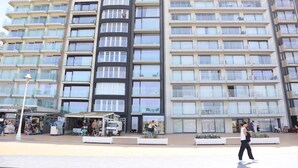 A multi-story hotel with balconies, a central courtyard, and a street-level retail area. - Apartment in Nieuwpoort by the Beach (Nieuwpoort)